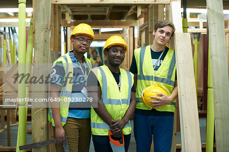 Three male higher education carpentry students in college workshop, portrait