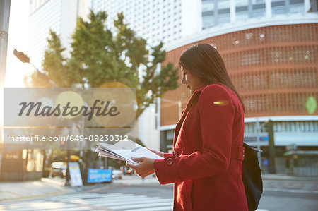 Businesswoman reading newspapers in city, Seoul, South Korea