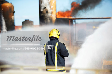 Fireman training to put out fire on burning tanks, Darlington, UK
