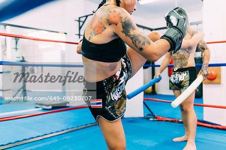 Male and female boxers working out in boxing ring