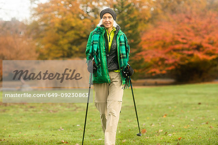 Mature woman nordic walking in park