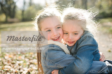 Sisters hugging in forest