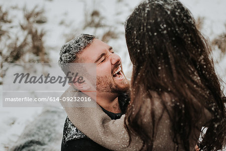 Couple laughing in snowy landscape