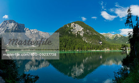 Braies lake in a clear day of summer season with mountains and blue sky in background, Dolomites - Italy