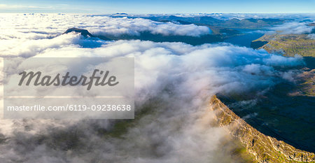 Aerial panoramic of clouds on the rocky peaks of Skaelingsfjall and Sornfelli mountains, Streymoy island, Faroe Islands, Denmark, Europe