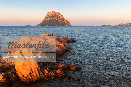 Sun illuminates rocks with Tavolara Island in the background at sunset, Loiri Porto San Paolo, Olbia Tempio province, Sardinia, Italy, Mediterranean, Europe