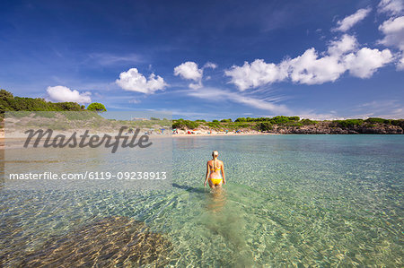 A girl in swimsuit walks in the water, La Bobba Beach, San Pietro Island, Sud Sardegna province, Sardinia, Italy, Mediterranean, Europe