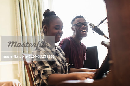 Teenage brother and sister playing piano and singing