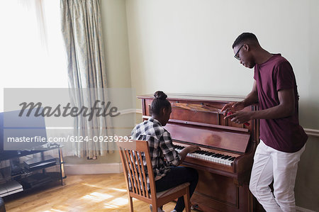 Brother and sister playing piano