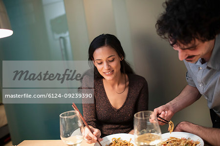 Couple eating dinner with chopsticks