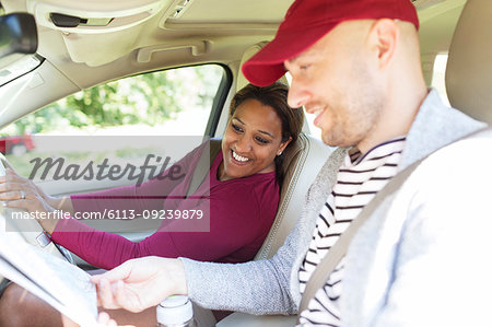 Couple looking at map in car on road trip