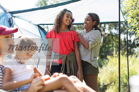 Affectionate mother brushing daughter hair at campsite