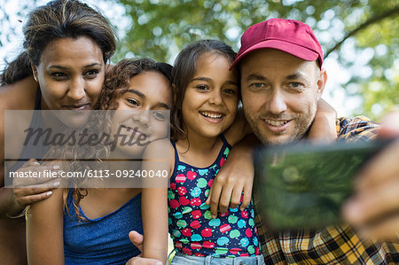 Happy family taking selfie with camera phone