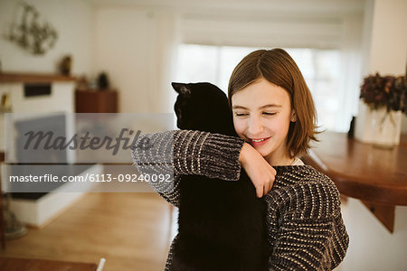 Affectionate girl holding black cat