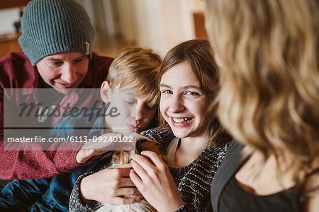 Portrait happy family petting guinea pig