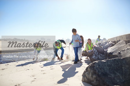 Volunteers cleaning up litter on sunny beach