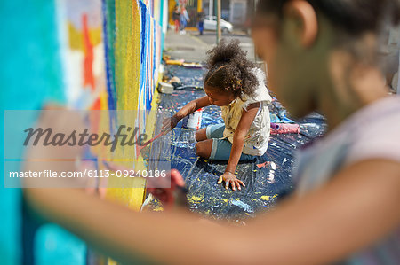 Girls painting mural on wall