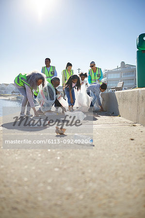 Volunteers picking up plastic litter on sunny boardwalk