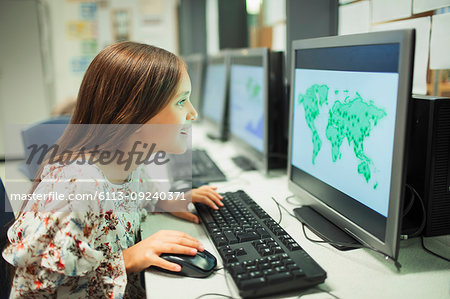 Curious junior high school girl student looking at map on computer in classroom