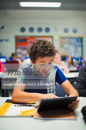 Junior high school boy student using digital tablet in classroom