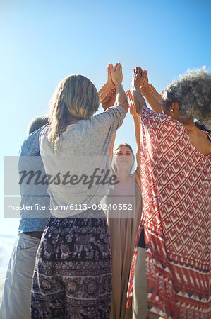 Group standing in circle with arms raised during yoga retreat