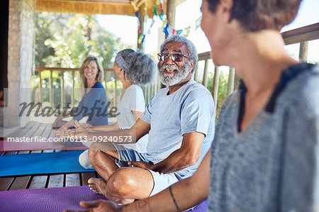 Senior man talking with woman in hut during yoga retreat