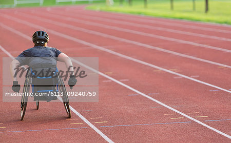 Female paraplegic athlete speeding along sports track in wheelchair race