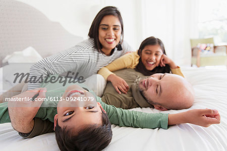 Happy family cuddling on bed