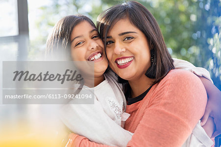 Portrait happy, confident, affectionate mother and daughter hugging