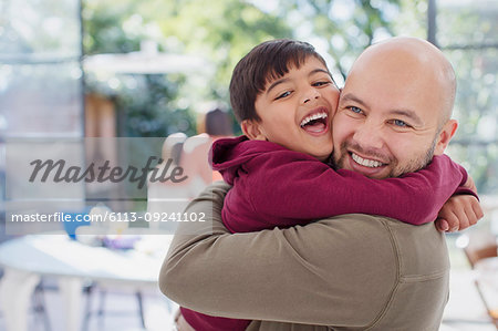 Happy, exuberant father and son hugging