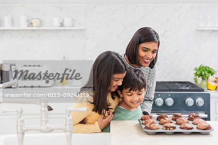 Mother and children baking chocolate muffins