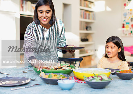 Mother serving dinner to family at dining table