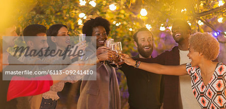 Friends celebrating, toasting champagne at dinner garden party