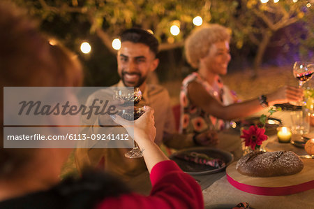 Friends toasting wine glasses at dinner garden party