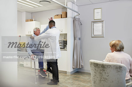 Doctor examining senior male patient in examination room