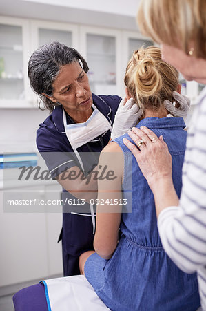 Female doctor examining girl patient in examination room