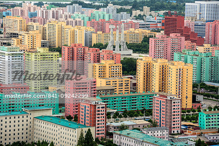 Workers' Party Monument amid painted blocks of flats, seen from Juche Tower, Pyongyang, North Korea, Asia