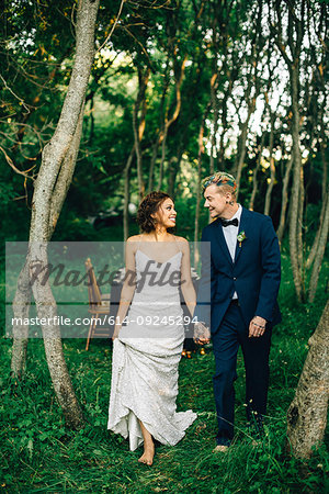 Romantic bride and groom strolling in forest