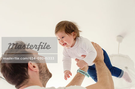 Father playing with baby girl at home