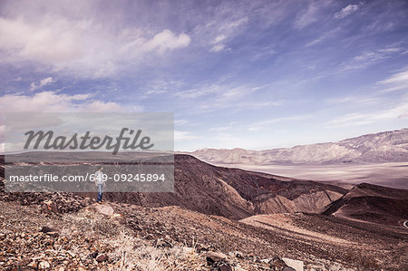 Man looking out over bleak arid landscape, Death Valley Junction, California, USA
