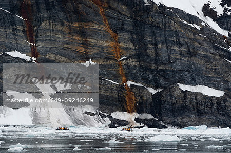 Tourists in dinghys near coastline, distant view, Burgerbukta, Spitsbergen, Svalbard, Norway.