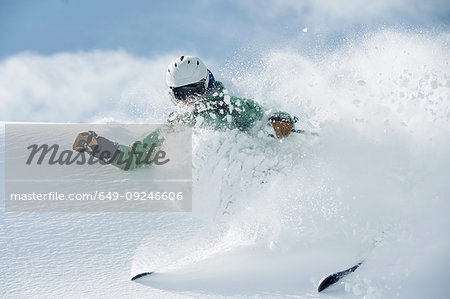 Male skier speeding down snow covered mountain, Alpe-d'Huez, Rhone-Alpes, France