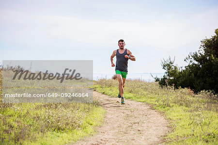 Runner jogging on cliff top, Santa Barbara, California, USA