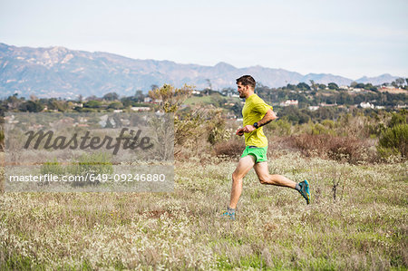 Runner jogging on cliff top, Santa Barbara, California, USA