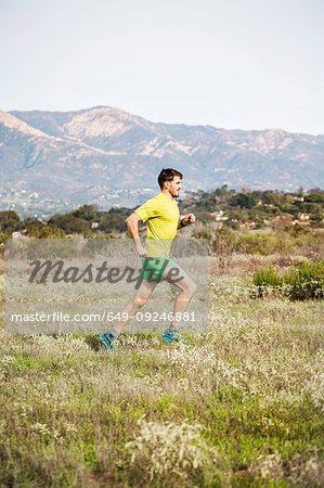 Runner jogging on cliff top, Santa Barbara, California, USA