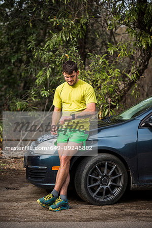 Runner checking time beside car