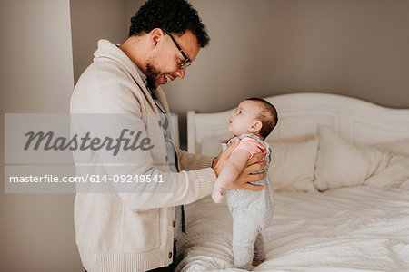 Father talking face to face with baby daughter