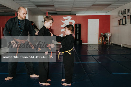 Coach and students practising martial arts in studio