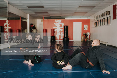 Coaches and students resting in martial arts studio