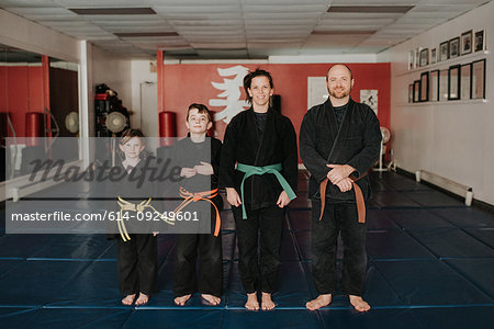 Coaches and students posing in martial arts studio